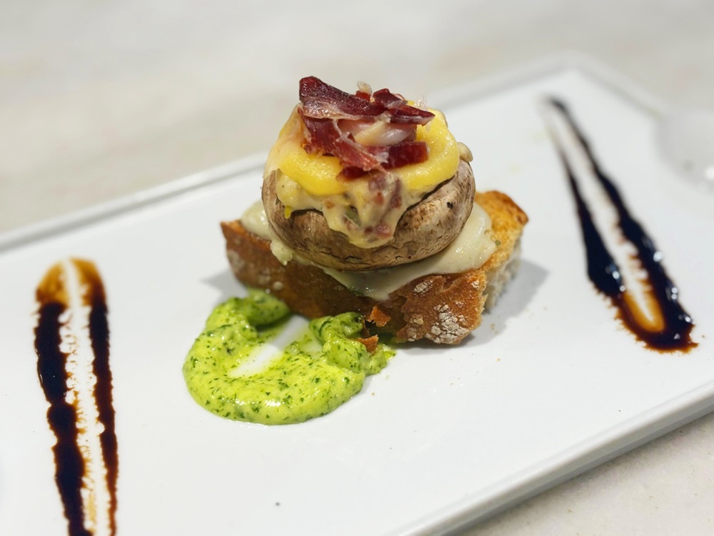 RESTAURANTE CONTINENTAL. Nombre: Champi. Champiñón relleno con una mezcla de puerro, champiñones, jamón y una reducción de verdejo Cuatro Rayas. Finalmente se hornea tras aderezarlo con queso Brie, virutas de jamón y una mahonesa especial de ajo y perejil. Tapa verdejo Cuatro Rayas. ( REGRESAMOS )